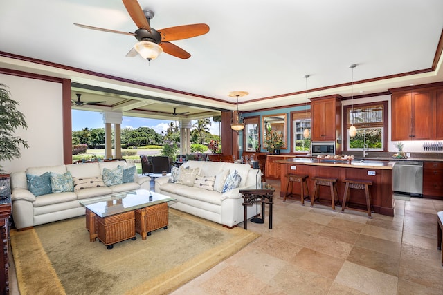 living area with ceiling fan and decorative columns