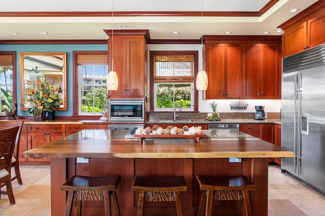kitchen with built in appliances, recessed lighting, ornamental molding, and a sink