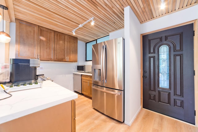 1875 Kalanianaole Ave Unit 311, Hilo, HI 96720 - kitchen featuring appliances with stainless steel finishes, brown cabinets, light wood-type flooring, track lighting, and light stone counters