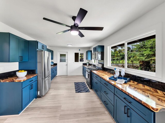 2427 Kaiwiki Rd, Hilo, HI 96720 - kitchen with stainless steel appliances, blue cabinetry, butcher block counters, and a sink