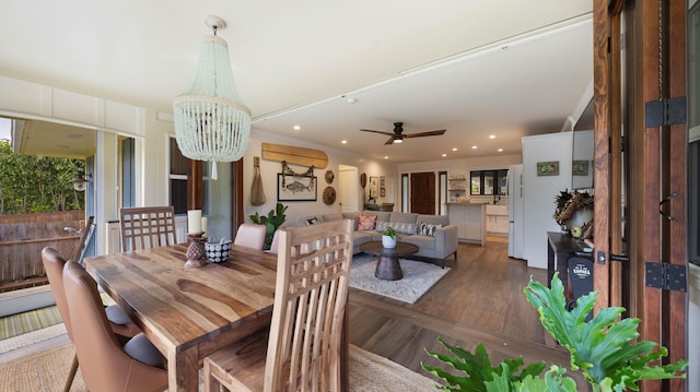 dining area with recessed lighting, wood finished floors, and ceiling fan with notable chandelier