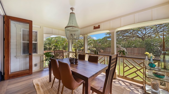 sunroom / solarium featuring a notable chandelier