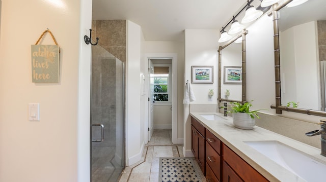 full bath featuring double vanity, a sink, and a stall shower
