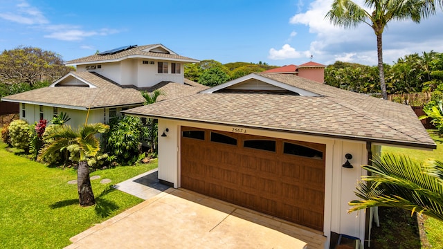 garage with driveway and solar panels
