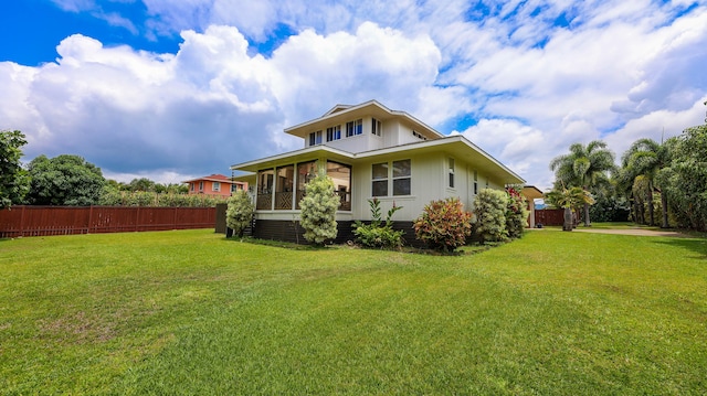 back of house with a sunroom, fence, and a yard