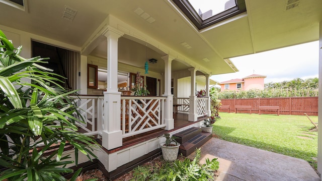 exterior space featuring covered porch, a lawn, fence, and visible vents