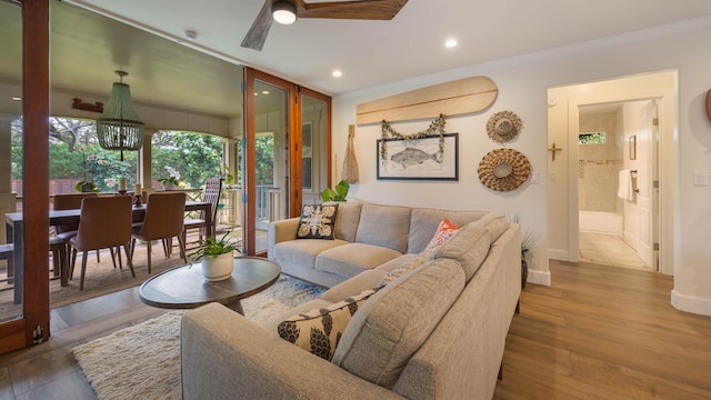 living area featuring crown molding, wood finished floors, baseboards, recessed lighting, and a ceiling fan