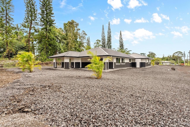rear view of house featuring metal roof