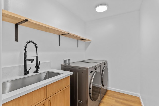 laundry room featuring cabinet space, independent washer and dryer, light wood-style floors, and baseboards