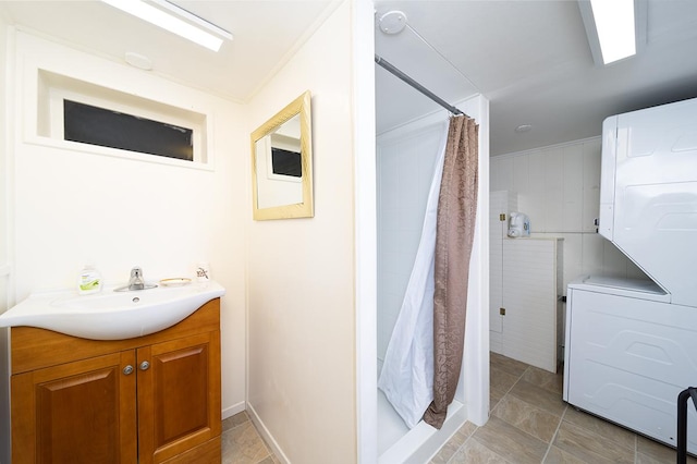full bathroom featuring a shower stall, stacked washing machine and dryer, and vanity