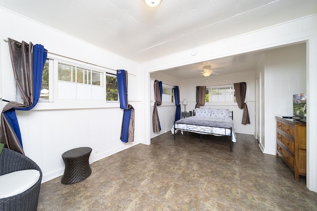bedroom featuring a ceiling fan and a decorative wall