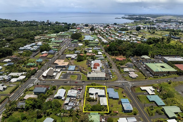 aerial view of property and surrounding area featuring a large body of water, property parcel outlined, and nearby suburban area