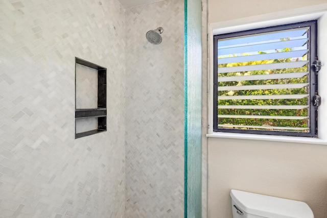 full bathroom featuring toilet and tiled shower
