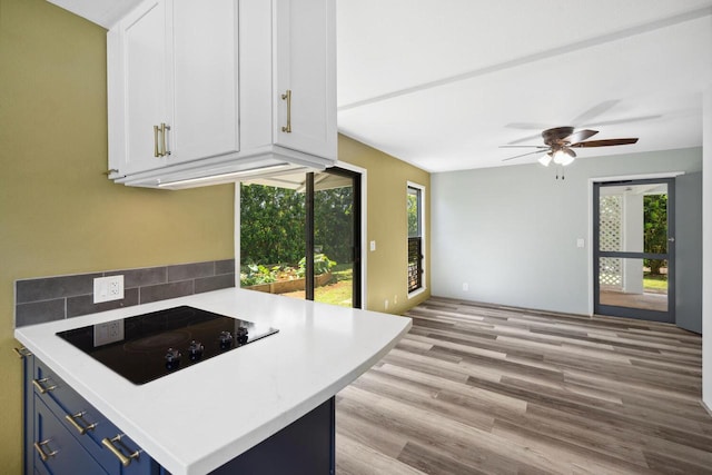 kitchen with white cabinetry, black electric stovetop, and blue cabinetry