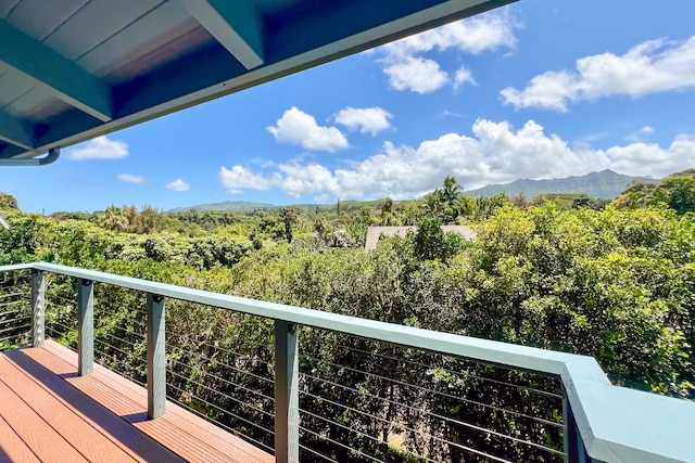 balcony featuring a wooded view and a mountain view