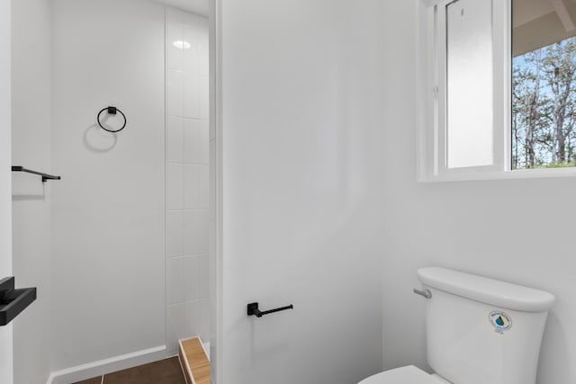 bathroom with baseboards and toilet