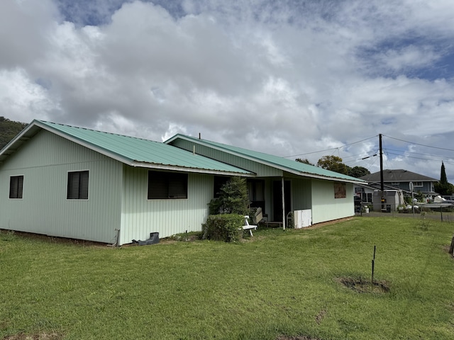 325 Kihapai St, Kapaa, HI 96746 - back of house featuring metal roof and a lawn