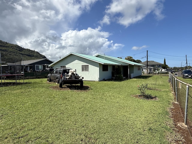 325 Kihapai St, Kapaa, HI 96746 - rear view of property featuring a yard, a trampoline, and fence