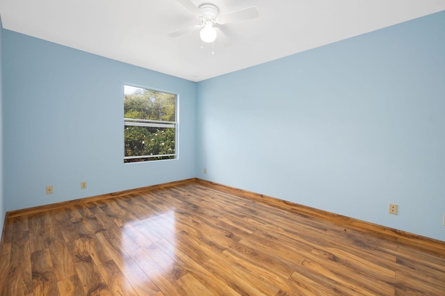 empty room with baseboards, a ceiling fan, and wood finished floors
