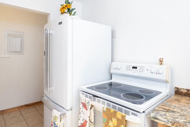 kitchen featuring light tile patterned floors, baseboards, electric panel, and white appliances