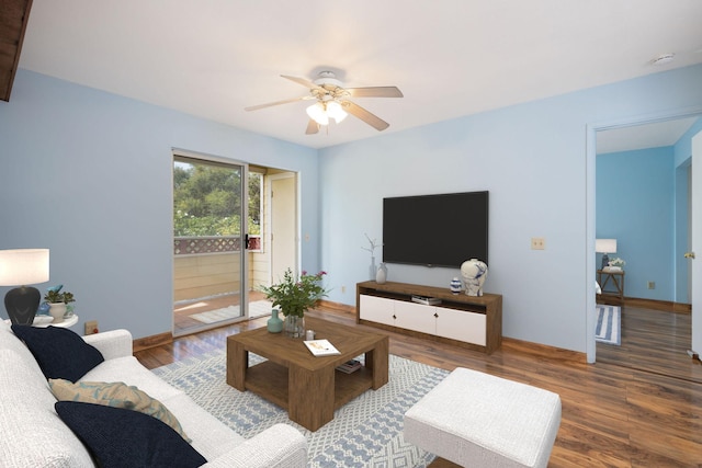 living room with baseboards, a ceiling fan, and wood finished floors