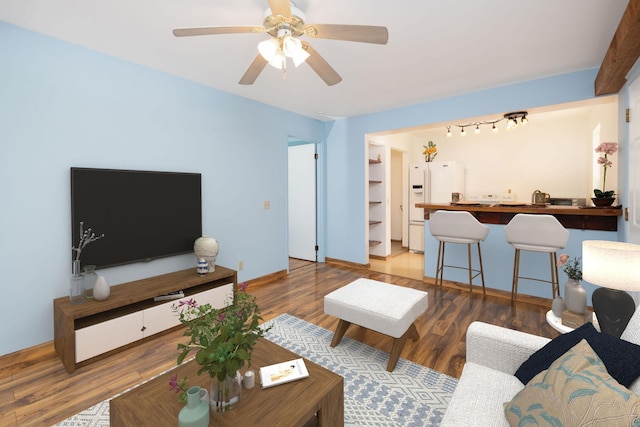 living area with a ceiling fan and wood finished floors