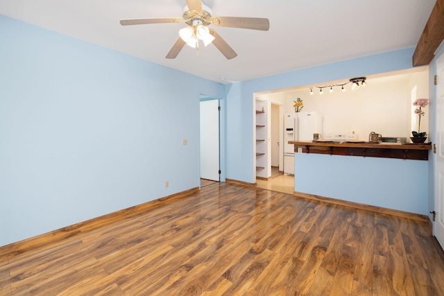 unfurnished living room with ceiling fan and wood finished floors