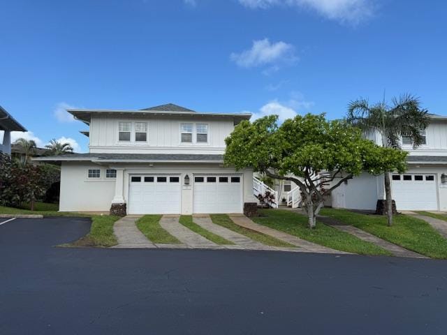 traditional-style house featuring a garage, stucco siding, and driveway