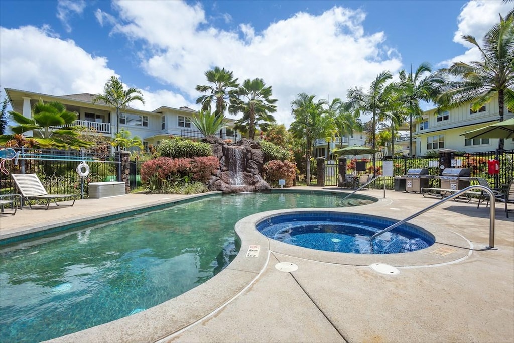 community pool featuring grilling area, a community hot tub, and fence