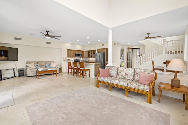 living area featuring a ceiling fan, decorative columns, stairs, and recessed lighting
