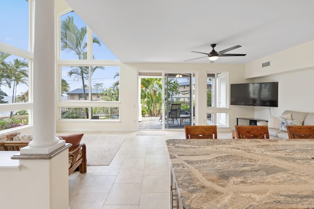 bedroom with access to outside, light tile patterned flooring, decorative columns, and a ceiling fan