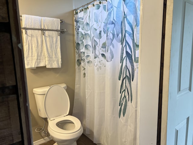 bathroom featuring a shower with shower curtain and toilet