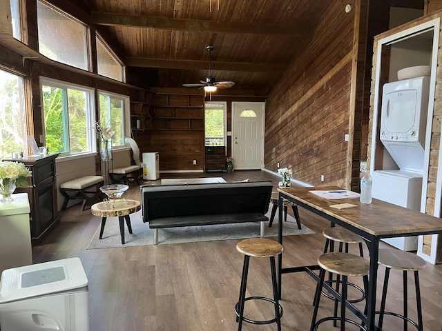 interior space featuring wood ceiling, stacked washer and dryer, and wooden walls