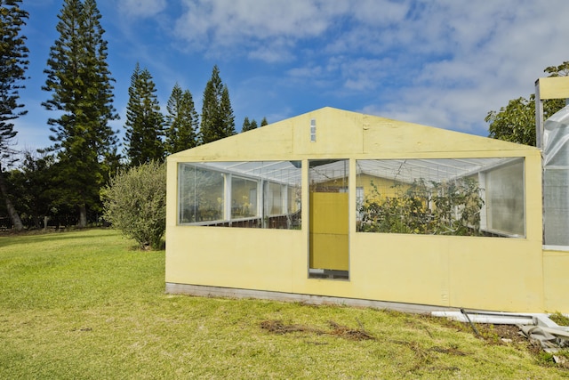 back of property with a yard and an exterior structure