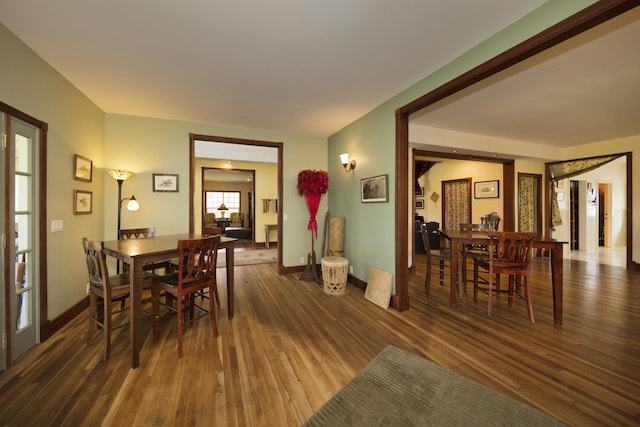 dining space with baseboards and wood finished floors