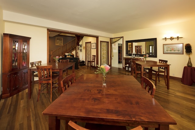 dining area with stairway, baseboards, and wood finished floors