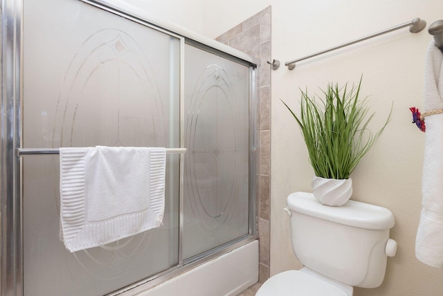 bathroom with toilet and enclosed tub / shower combo