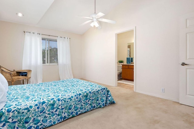 bedroom with lofted ceiling, light colored carpet, ensuite bath, ceiling fan, and baseboards