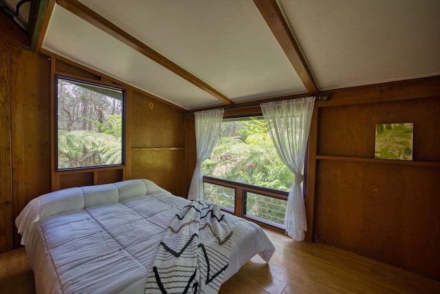 bedroom with wood finished floors and wood walls