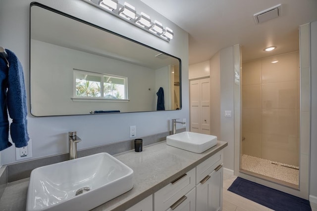 bathroom featuring visible vents, a shower stall, double vanity, and a sink