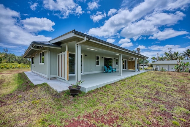 rear view of house with a patio and a lawn