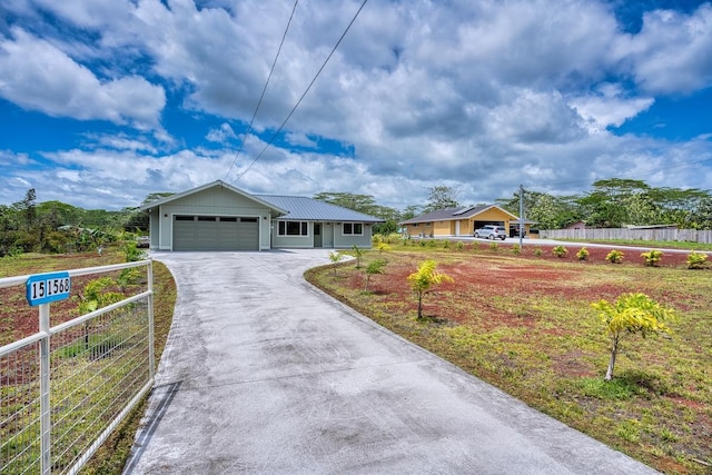 ranch-style house featuring metal roof, an attached garage, aphalt driveway, and fence