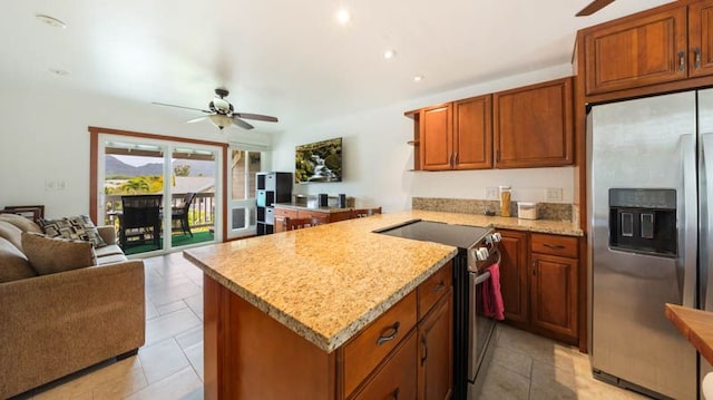 kitchen featuring stainless steel appliances, a ceiling fan, open floor plan, a peninsula, and light stone countertops
