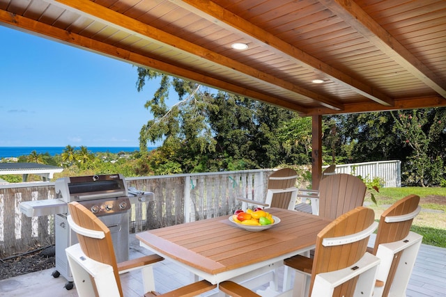 wooden deck featuring outdoor dining area, a water view, and grilling area