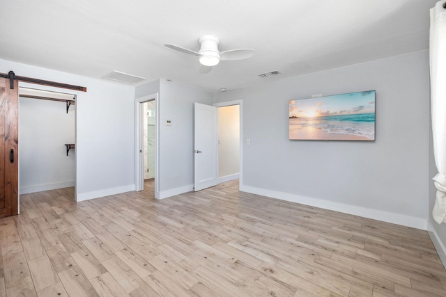 unfurnished bedroom with baseboards, ceiling fan, visible vents, and wood finished floors