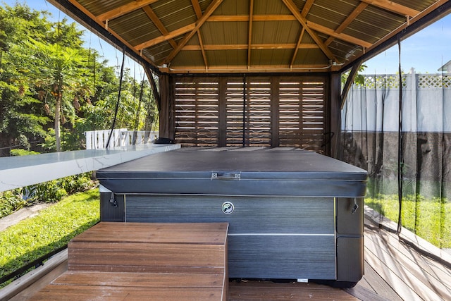 wooden terrace featuring fence, a gazebo, and a hot tub
