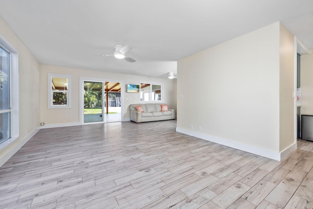 unfurnished living room featuring baseboards, light wood finished floors, and ceiling fan