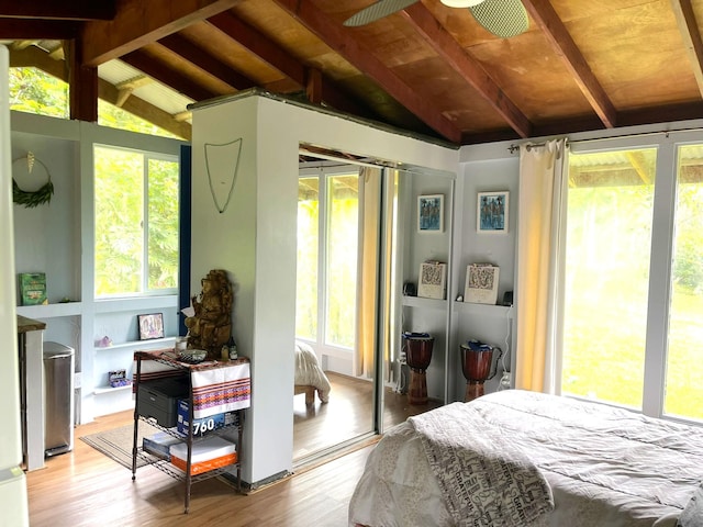 bedroom with vaulted ceiling with beams, a closet, and wood finished floors