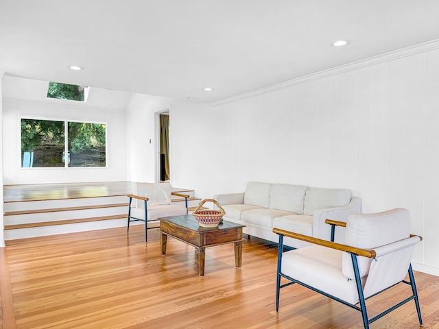 living area featuring wood finished floors, recessed lighting, and crown molding