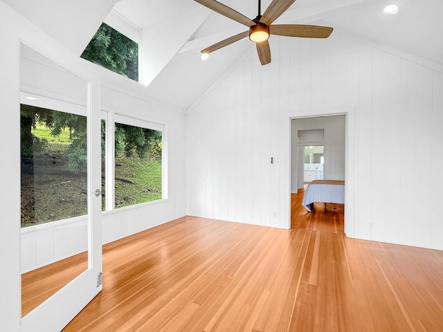 unfurnished room featuring light wood-type flooring, a ceiling fan, and vaulted ceiling